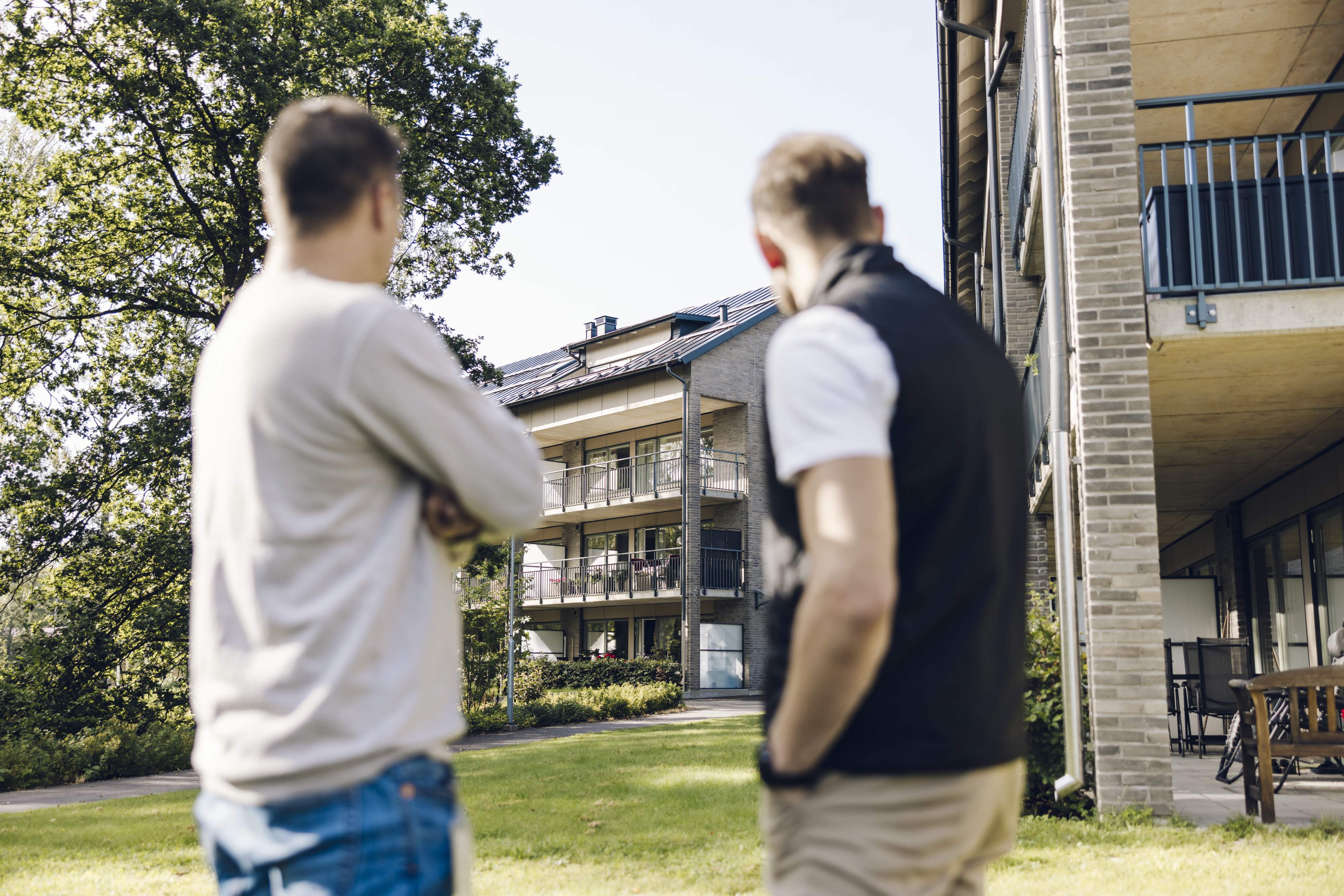 Två män står och tittar på en fastighet