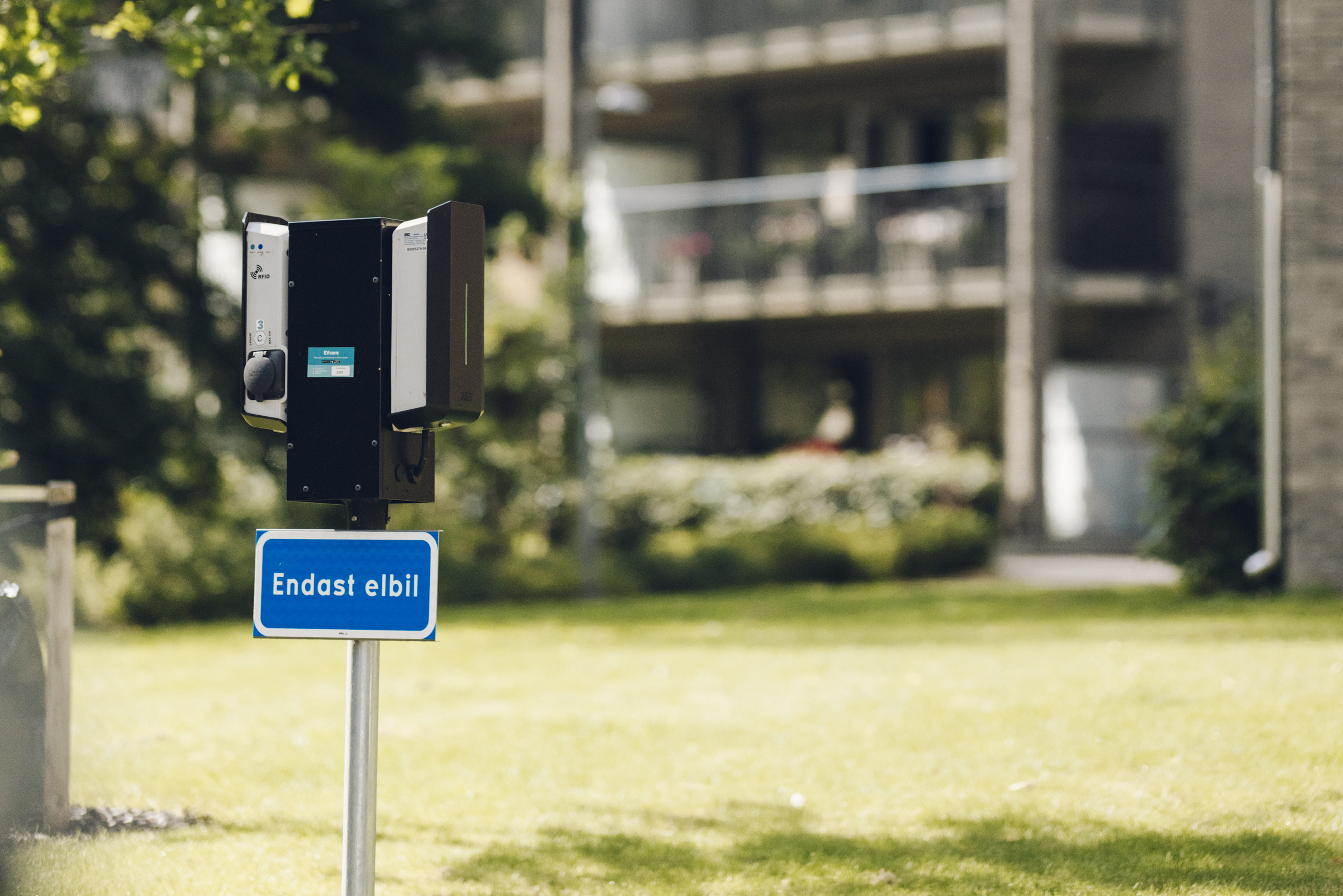 Blå skylt för elbilsladdning i bostadsområde
